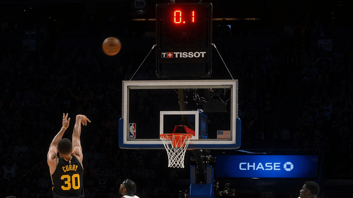 NBA shot clock glowing red above the hoop during a last-second shot attempt.