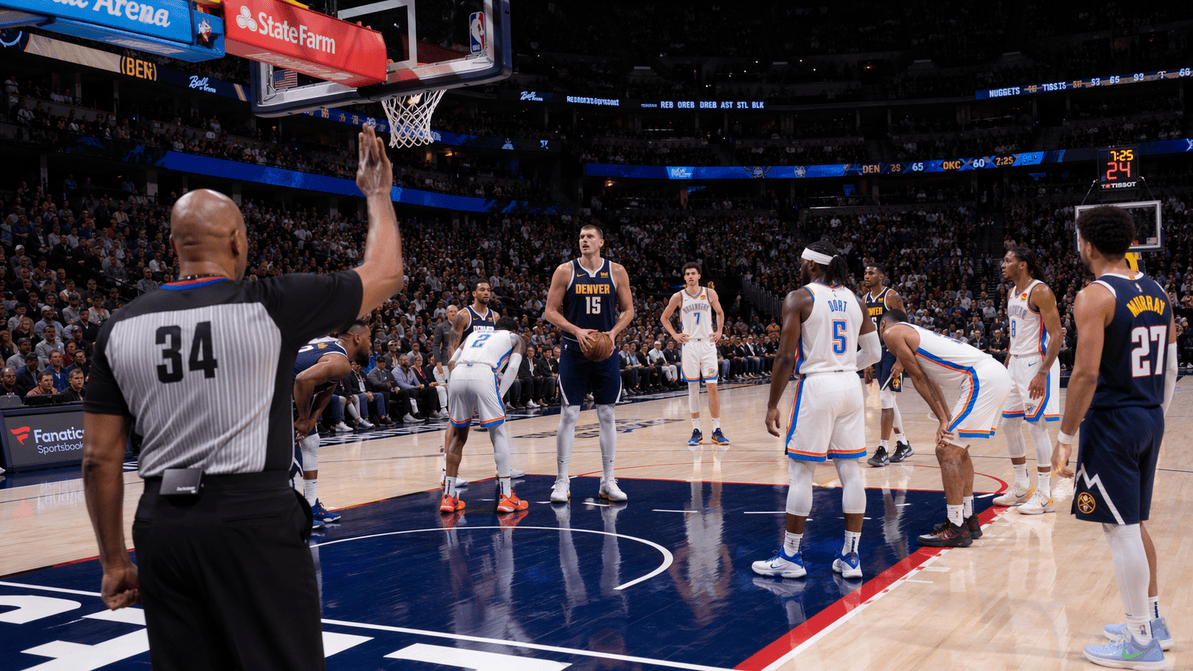 Basketball referee monitoring the 3-second lane violation during a game.