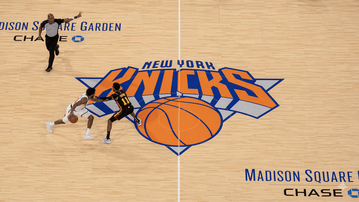 Basketball player trying to cross the midcourt line under defensive pressure.