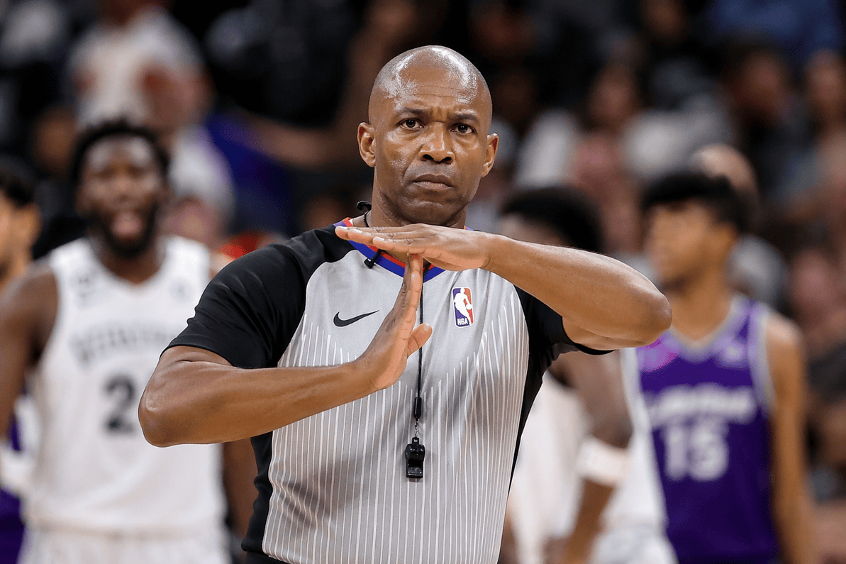 Basketball referee signaling a technical foul with a T hand gesture.